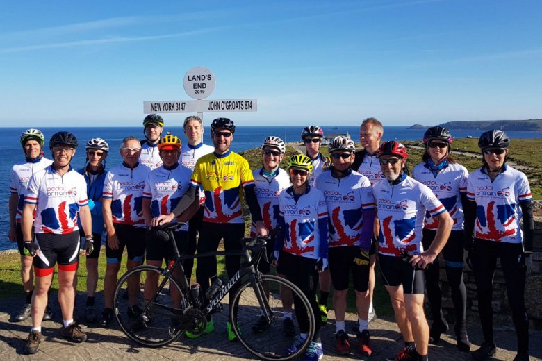 Pedal britain group of cyclists at land's end.