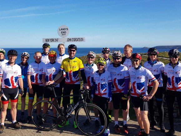 Pedal britain group of cyclists at land's end.